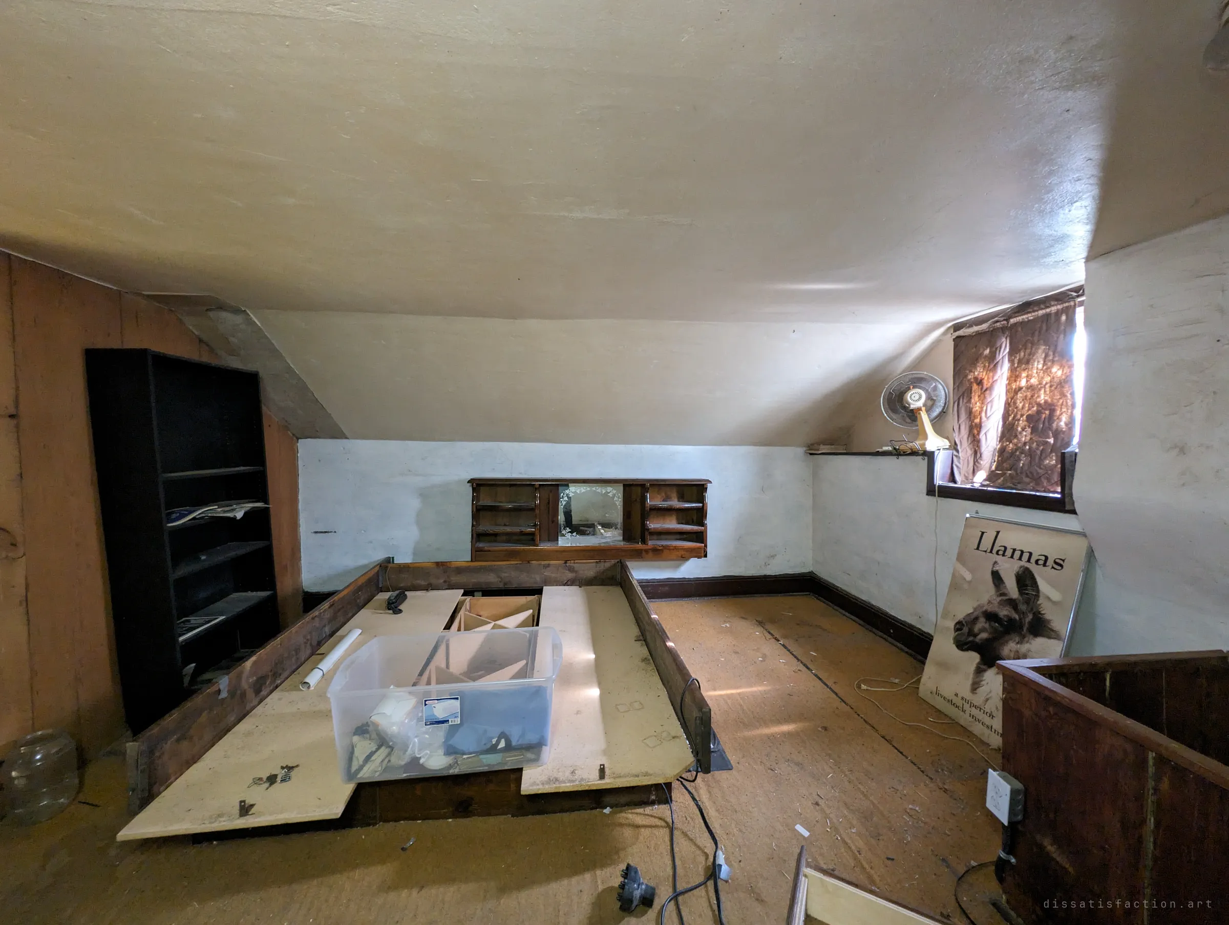 An attic bedroom under a sloped ceiling, its bed frame pulled apart, with an old llama livestock poster leaning against the wall. The poster hints at the farm's past life.