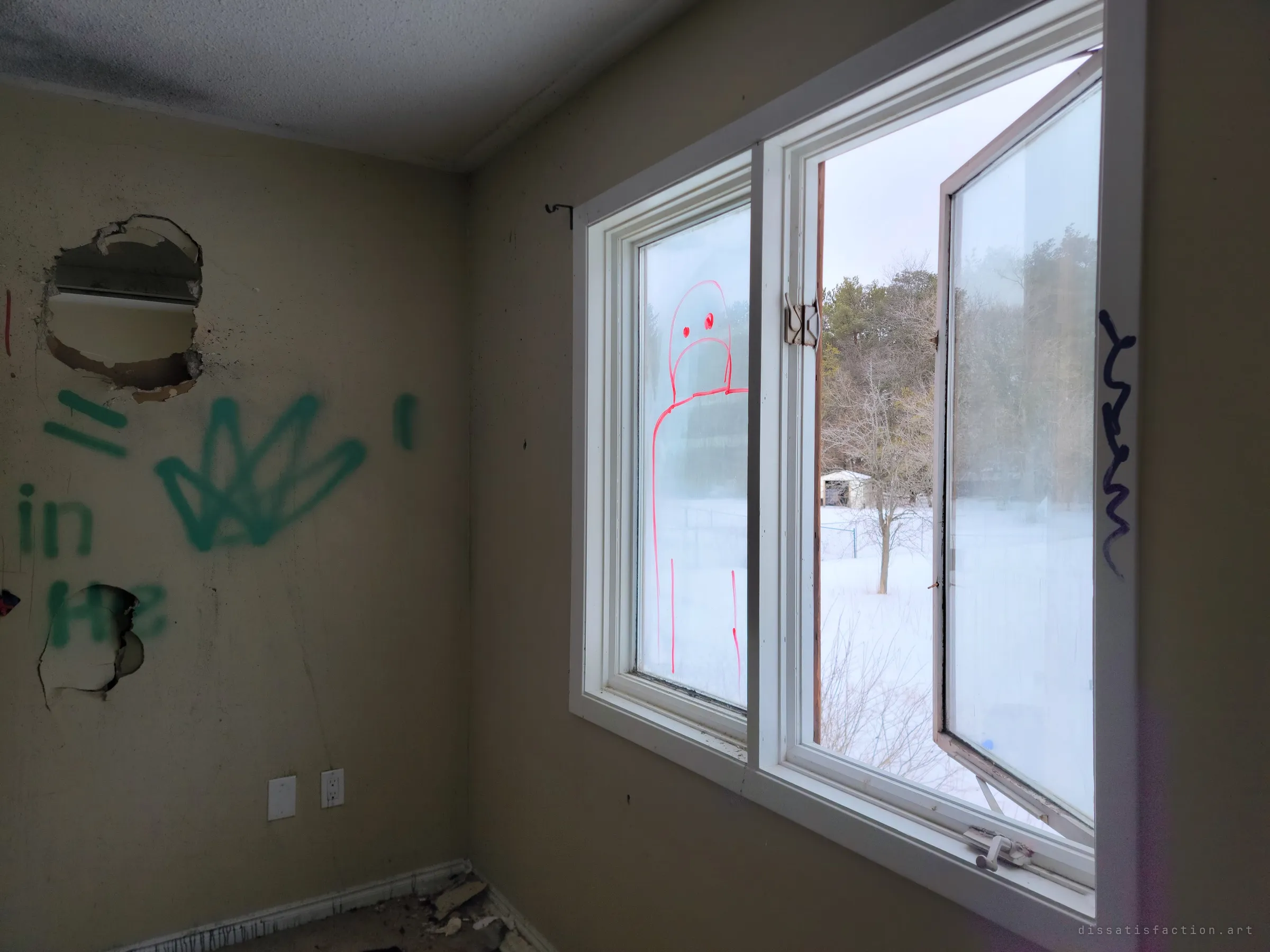 Corner of a graffitied bedroom with a casement window swung open onto a snowy yard, a red marker ghost figure drawn on the glass. Winter light from outside falls on the smashed and tagged walls.