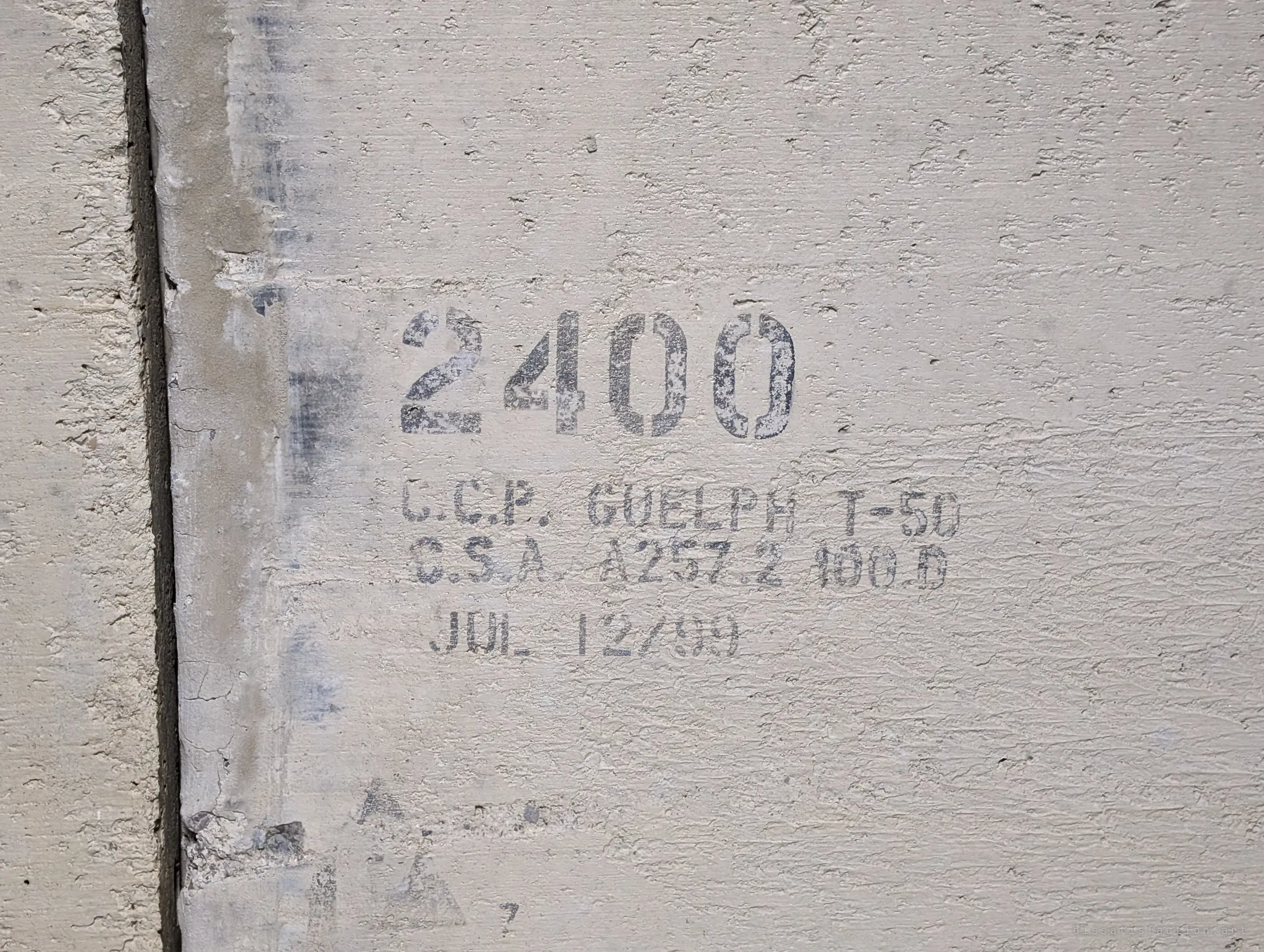 A stencilled size marking and a 1999 casting date on the concrete wall of the pipe, next to a joint between sections.