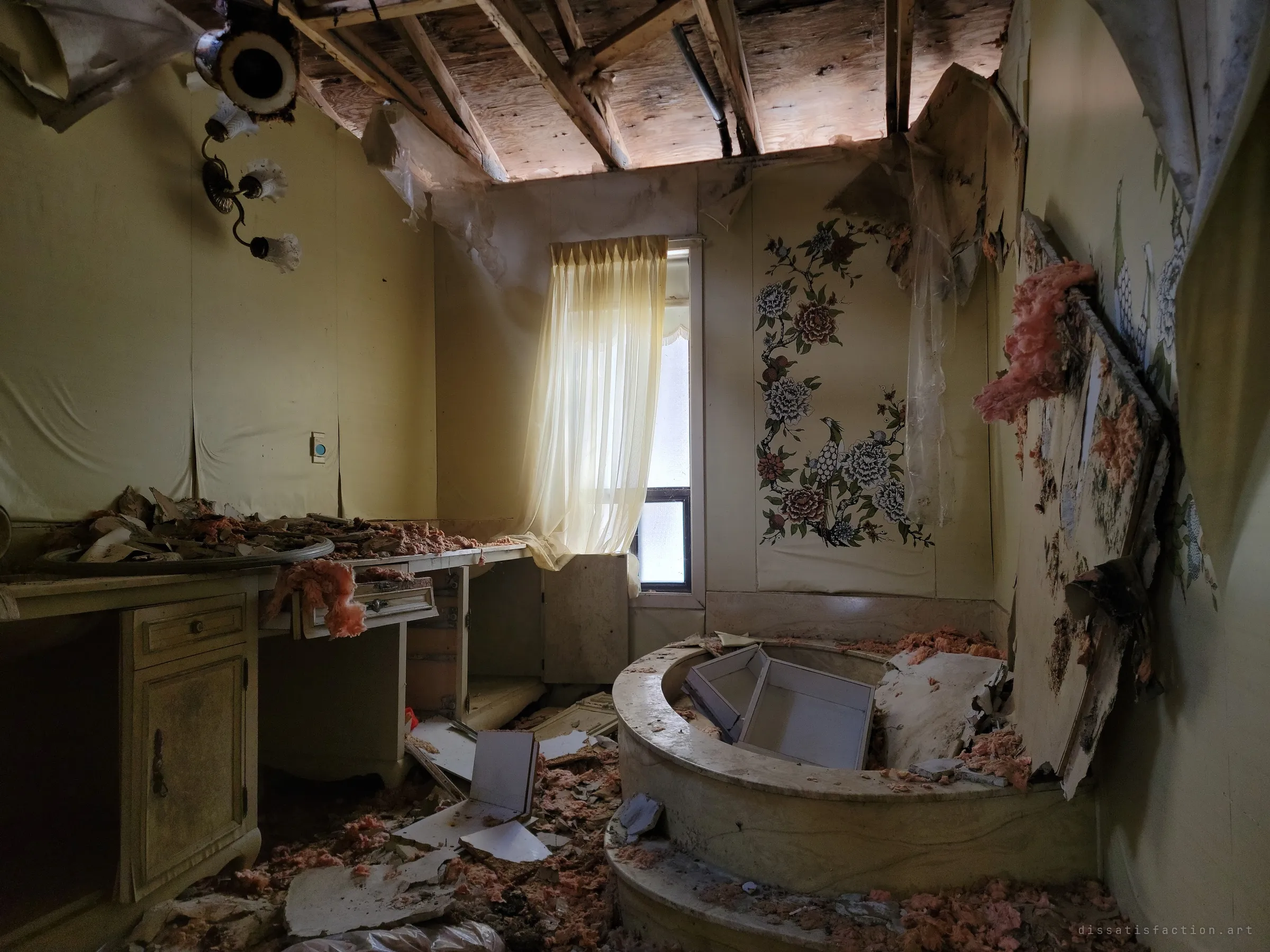 An ensuite with a sunken marble tub and a hand-painted bird-and-peony mural, the ceiling stripped to its joists and debris covering every surface.
