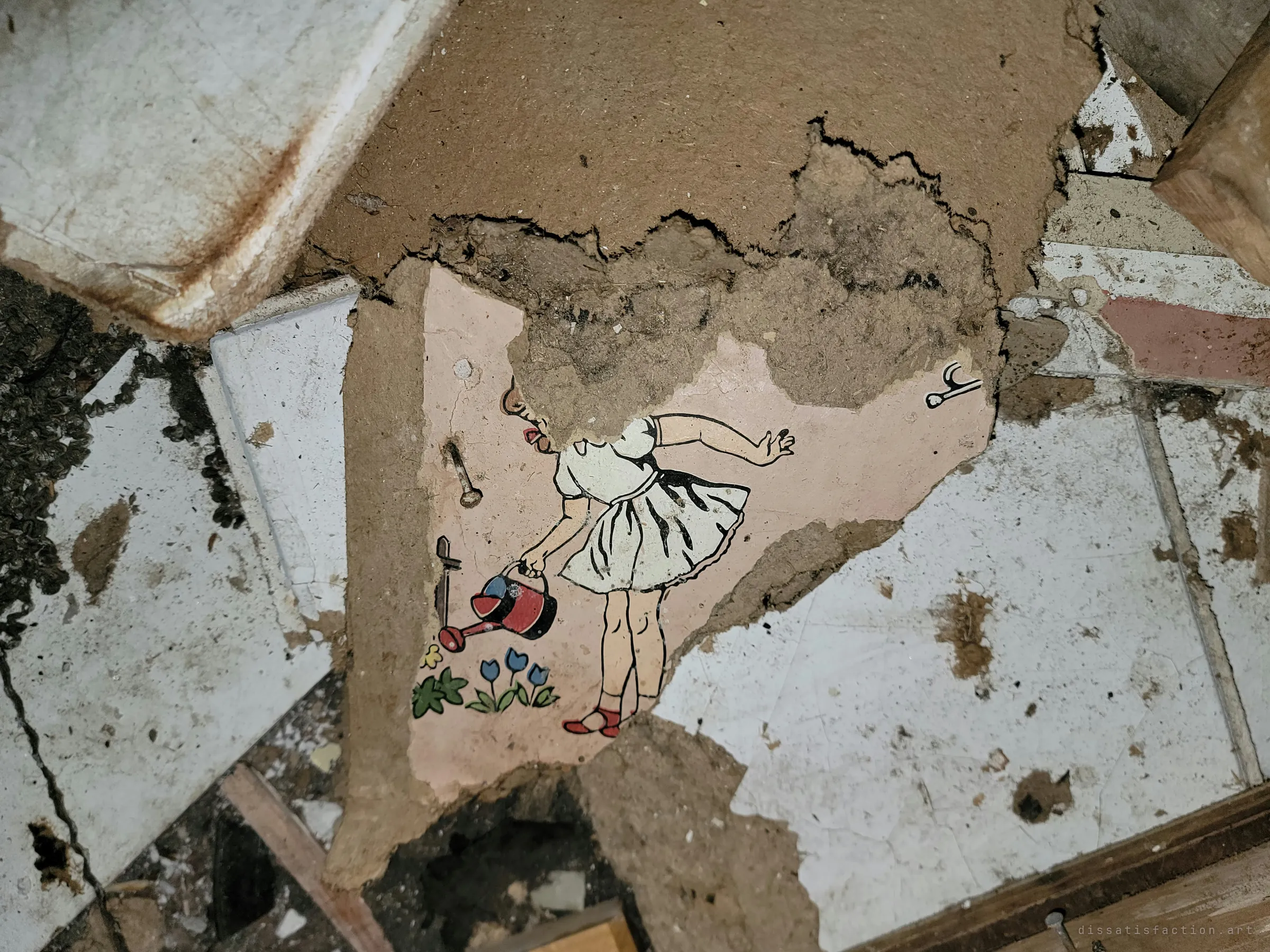 A shard of pink nursery wall on the floor still shows a painted girl watering tulips, her face torn away with the plaster. A small trace of a childhood among the rubble.