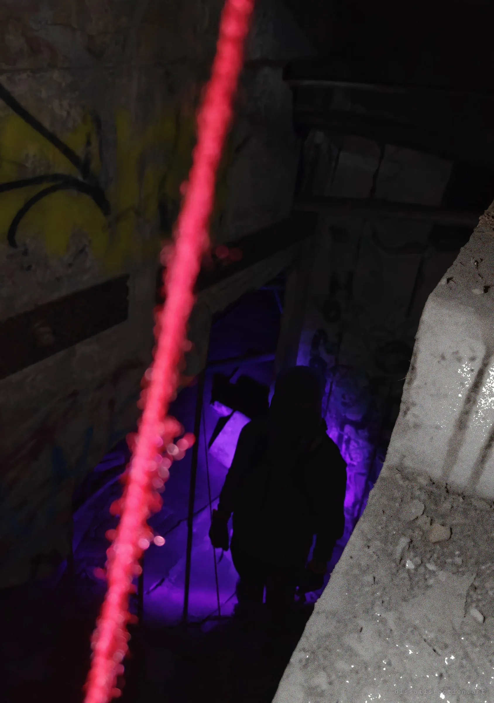 Looking down a shaft past an out-of-focus red rope to a silhouetted explorer lit in violet at the bottom, the climb's scale felt through the blur.