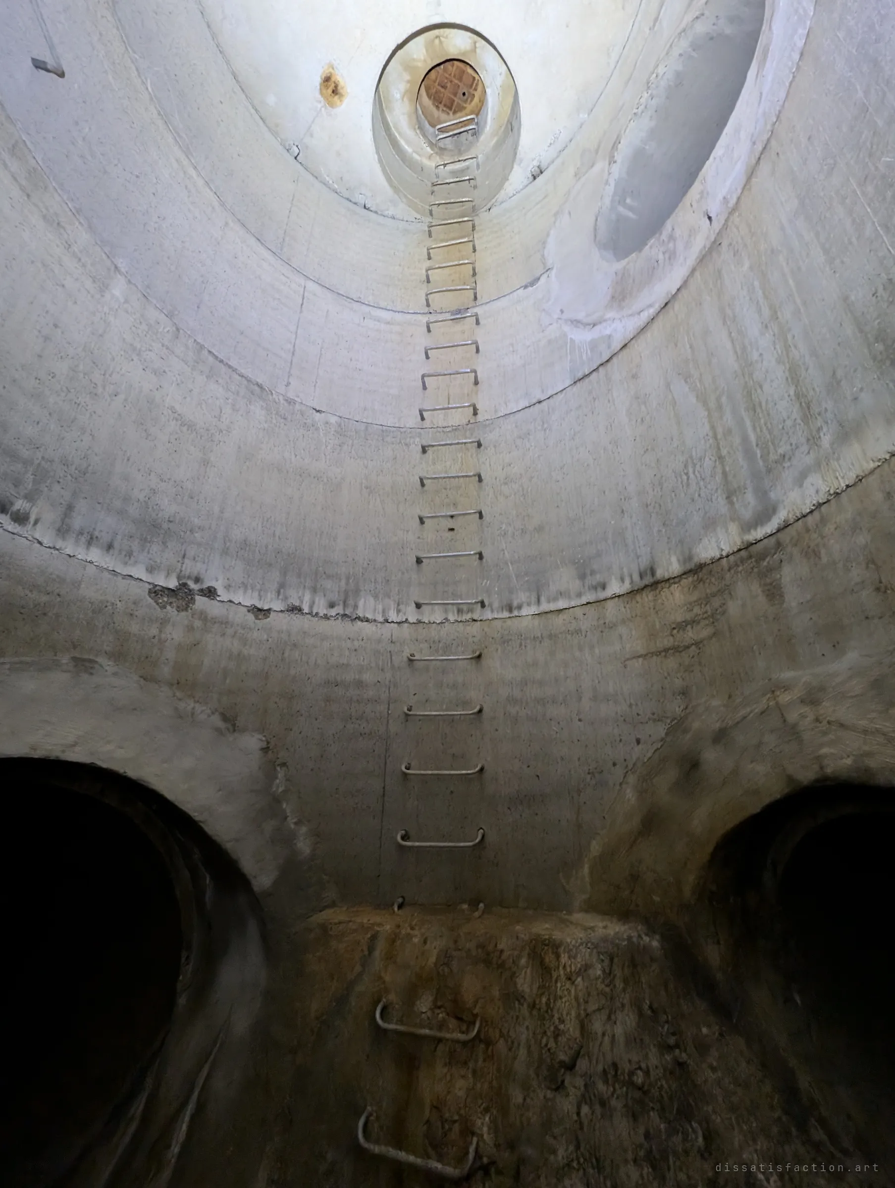 Looking up a tall concrete shaft, a long ladder of steel rungs climbs past two pipe outlets towards a small grated opening far above. The height of the climb gives the album its name.