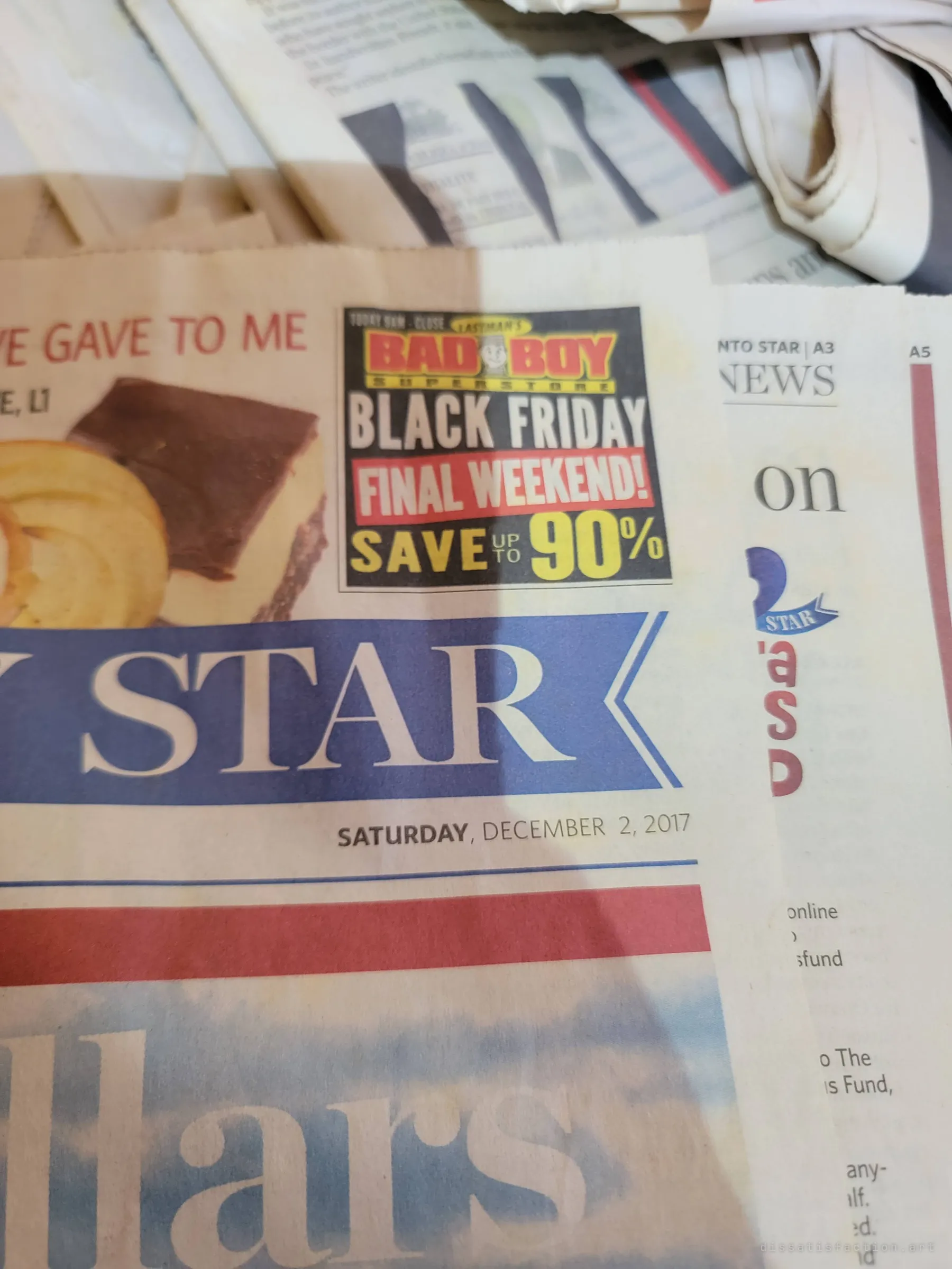 Close-up of a weekend newspaper front page dated December 2017 with a Black Friday advert. It is the most recent thing found in the house, marking roughly when it was left.