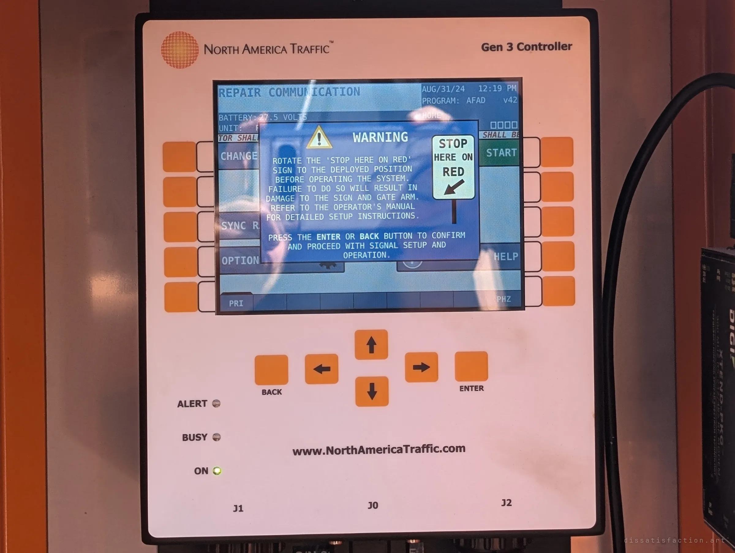 The signal controller's screen shows a setup warning, reflections of the photographer ghosting across the display. Someone left the system powered on.