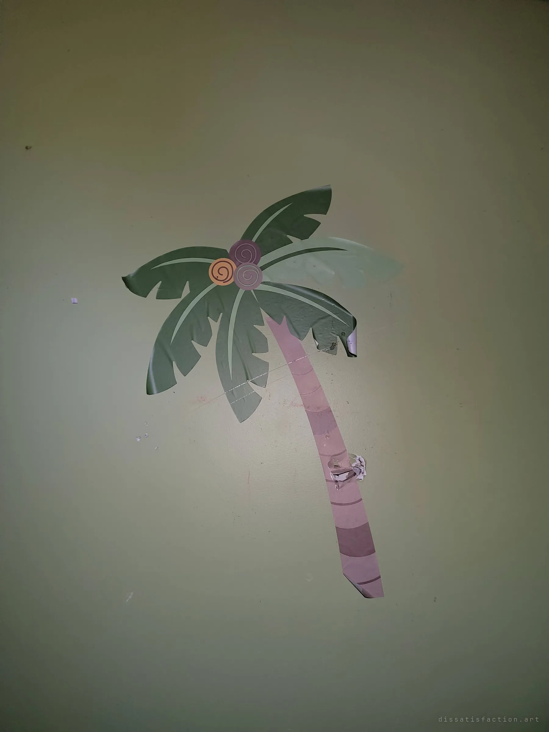 A peeling palm-tree wall decal on a dim green wall, its trunk torn and corners curling. The jungle-themed nursery is slowly coming off the walls.
